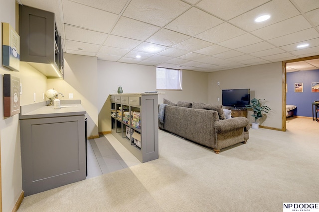 living room featuring light carpet, a drop ceiling, recessed lighting, and baseboards