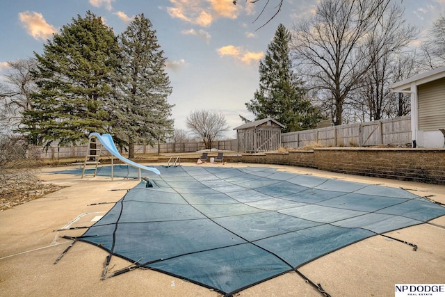 view of swimming pool with a fenced in pool, a patio, a water slide, and a fenced backyard