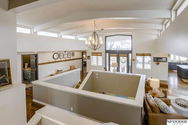 bathroom featuring a wealth of natural light, an inviting chandelier, wood finished floors, and lofted ceiling with beams