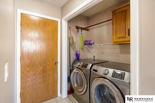 laundry area with cabinet space, independent washer and dryer, and light tile patterned flooring