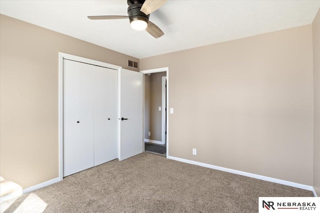 unfurnished bedroom with carpet flooring, baseboards, visible vents, and a closet