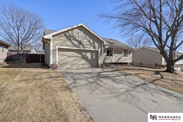 view of front of property featuring a garage, concrete driveway, and fence