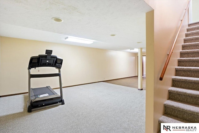 workout room featuring carpet, baseboards, and a textured ceiling