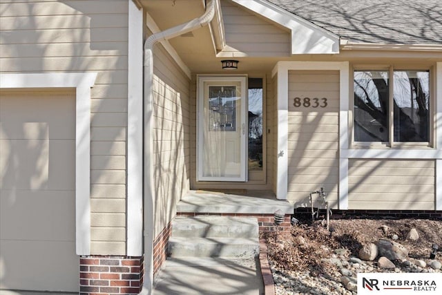 entrance to property featuring roof with shingles