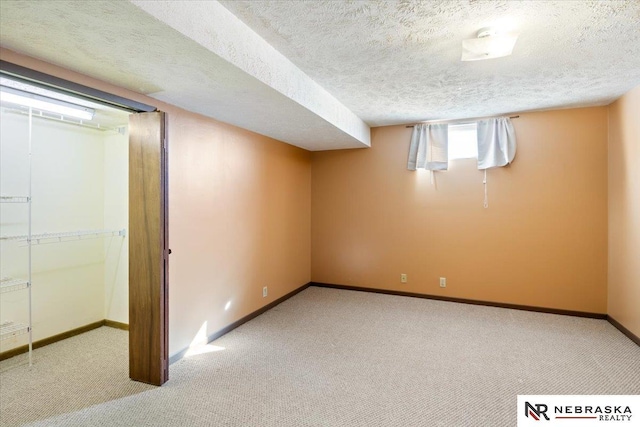 below grade area featuring carpet flooring, baseboards, and a textured ceiling