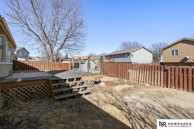 view of yard with a wooden deck, a residential view, and a fenced backyard