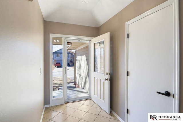 foyer entrance featuring light tile patterned floors and baseboards