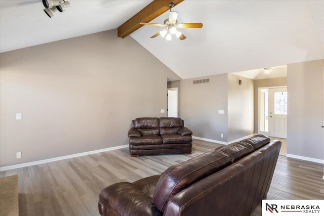 living area featuring visible vents, beam ceiling, baseboards, and wood finished floors