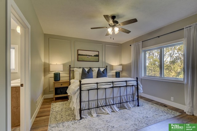 bedroom featuring visible vents, baseboards, and wood finished floors