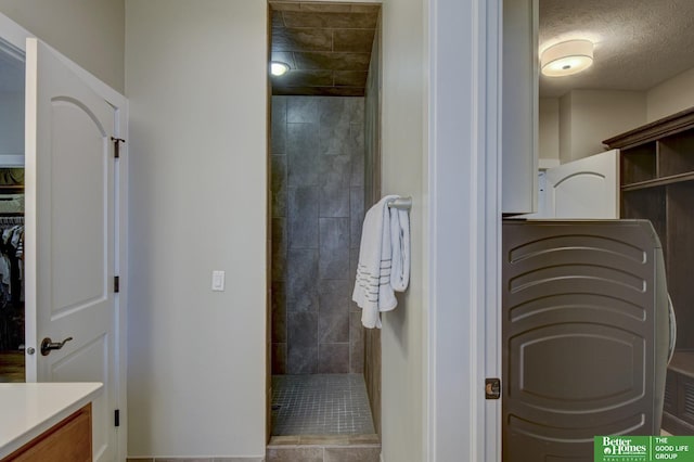 full bathroom featuring a textured ceiling, vanity, a closet, and walk in shower