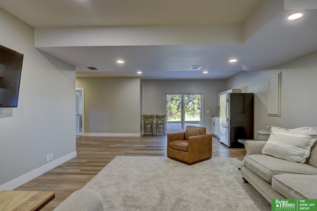 living room featuring recessed lighting, visible vents, baseboards, and wood finished floors