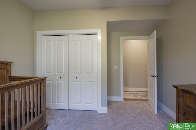 carpeted bedroom featuring baseboards and a closet