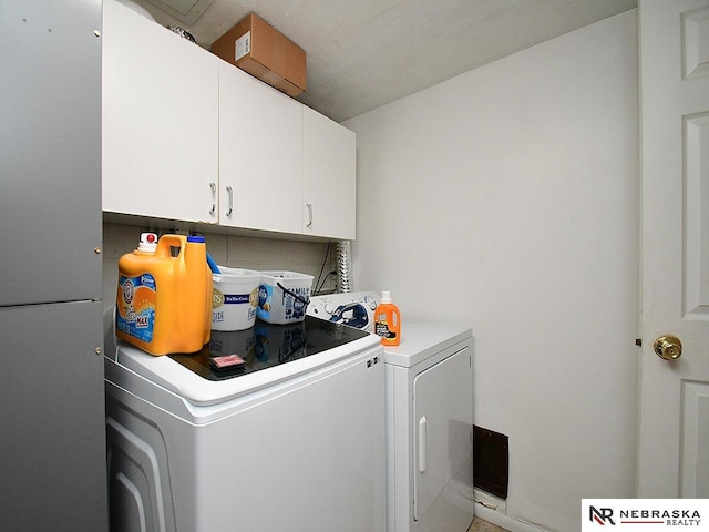 washroom featuring washing machine and clothes dryer and cabinet space