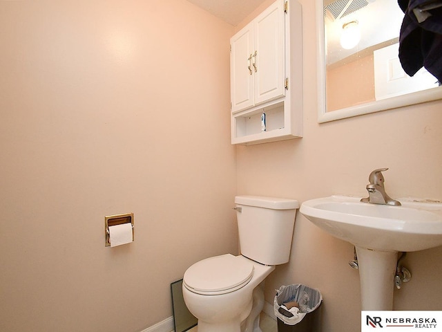 bathroom featuring toilet and baseboards