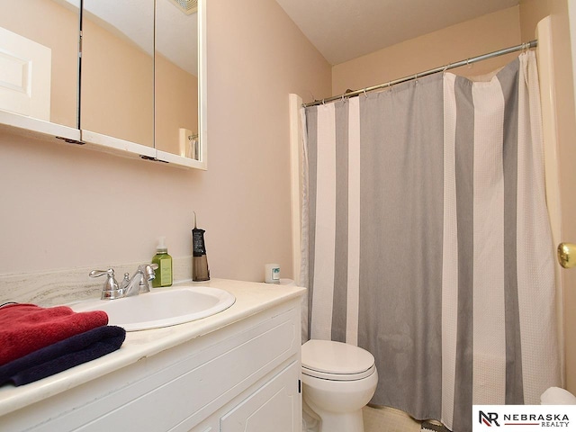 bathroom with curtained shower, toilet, and vanity