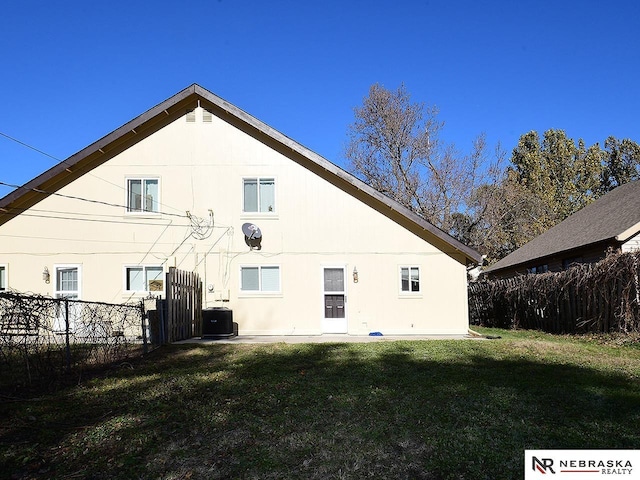 rear view of property featuring a yard, central air condition unit, stucco siding, and fence