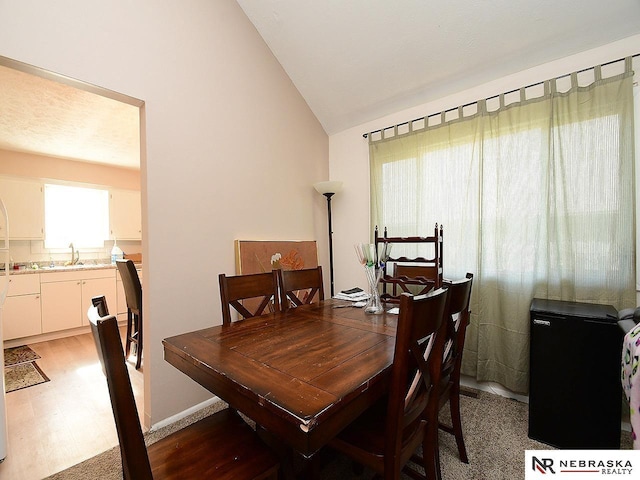 dining space with lofted ceiling and light wood finished floors