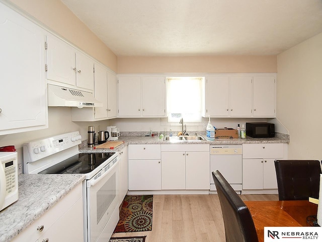 kitchen featuring white appliances, a sink, light wood-style floors, under cabinet range hood, and white cabinetry