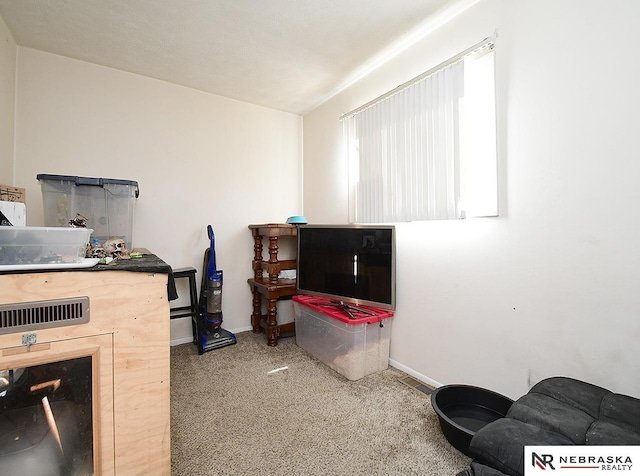 carpeted office space with a fireplace and baseboards