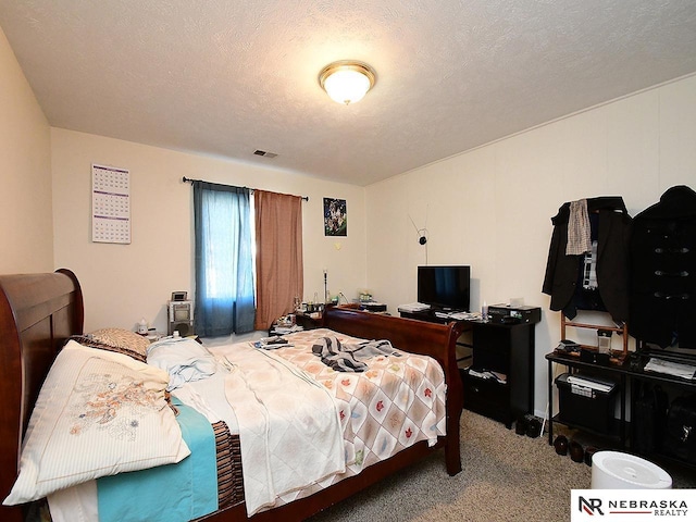 carpeted bedroom featuring visible vents and a textured ceiling