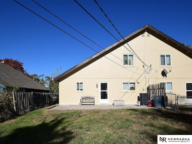 rear view of house with a patio area, cooling unit, a yard, and fence