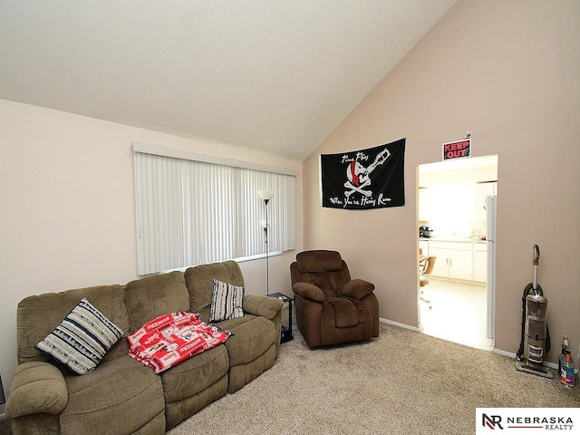 carpeted living area with vaulted ceiling and baseboards