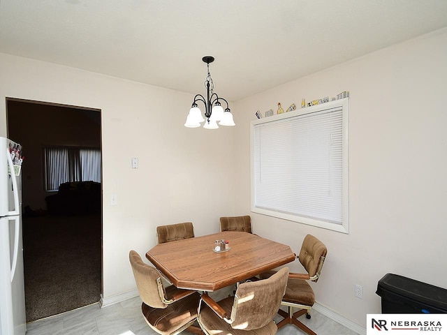 dining space featuring baseboards and a chandelier