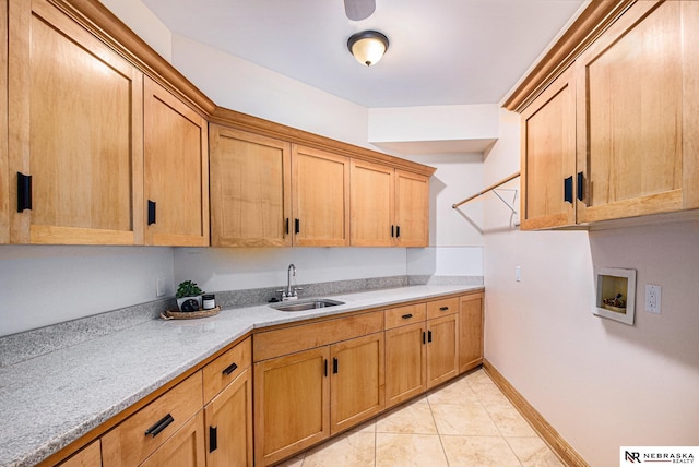 kitchen featuring light tile patterned floors, visible vents, baseboards, a sink, and light countertops