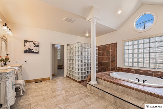 full bath with baseboards, decorative columns, lofted ceiling, a bath, and vanity