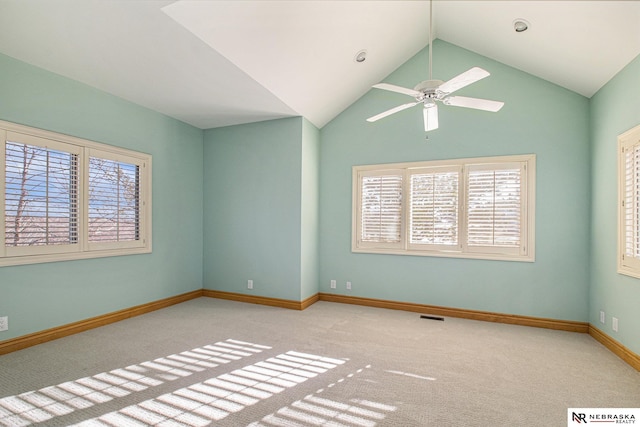 carpeted empty room with visible vents, ceiling fan, lofted ceiling, and baseboards