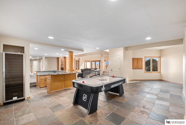 recreation room featuring stone tile floors, recessed lighting, and baseboards