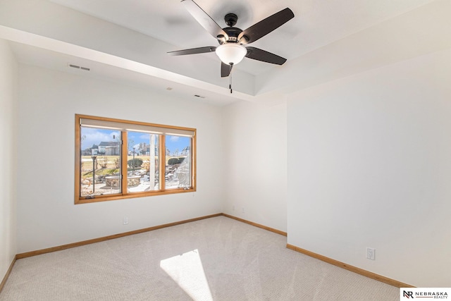 spare room with visible vents, light colored carpet, a ceiling fan, and baseboards