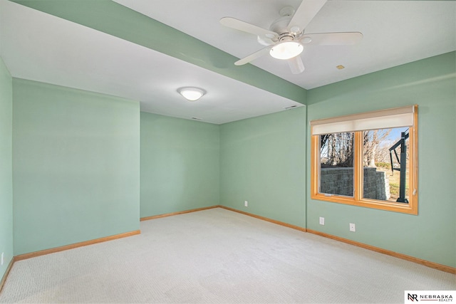 spare room featuring carpet, baseboards, and ceiling fan