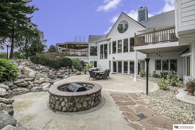 view of patio featuring a fire pit and a balcony