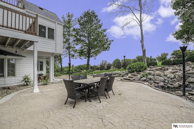 view of patio with outdoor dining area and a balcony