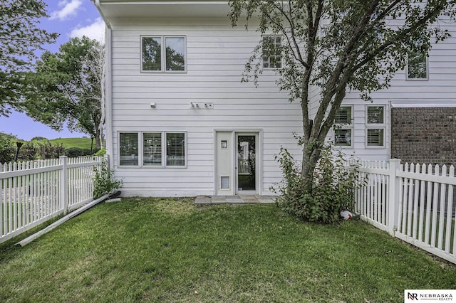 back of house featuring a yard and a fenced backyard