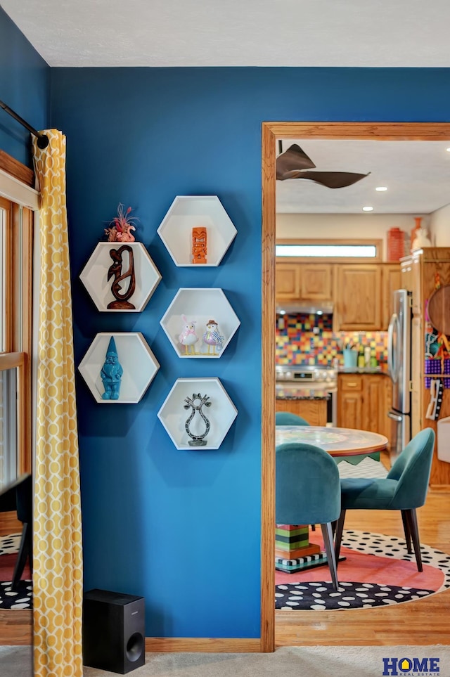 room details featuring under cabinet range hood, range, and freestanding refrigerator