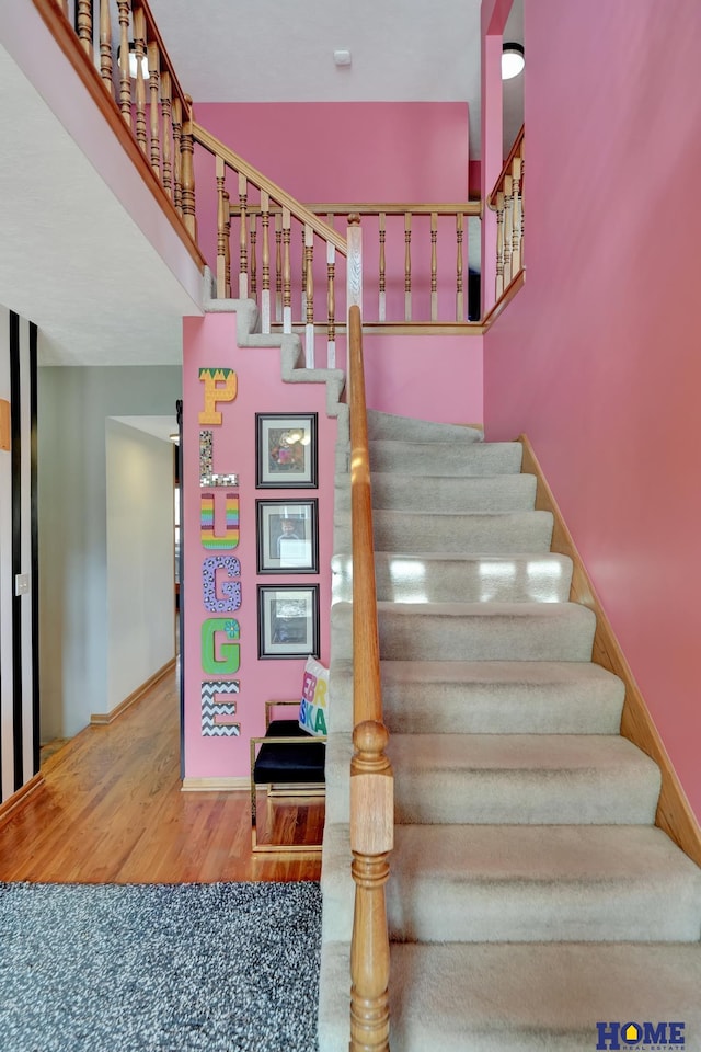 stairway with wood finished floors and baseboards