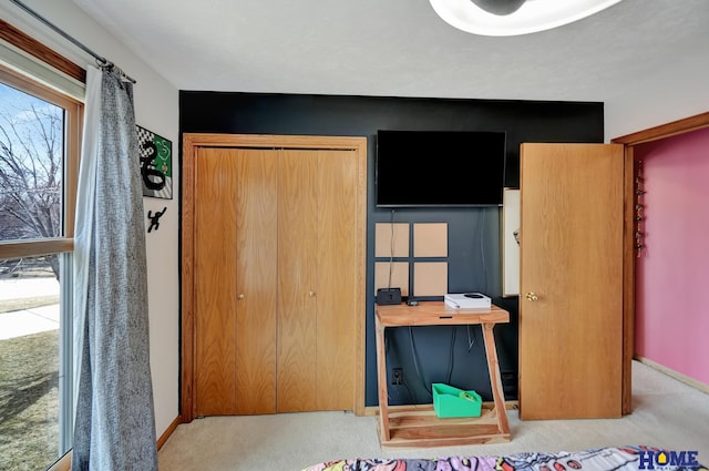 carpeted bedroom featuring baseboards and a closet