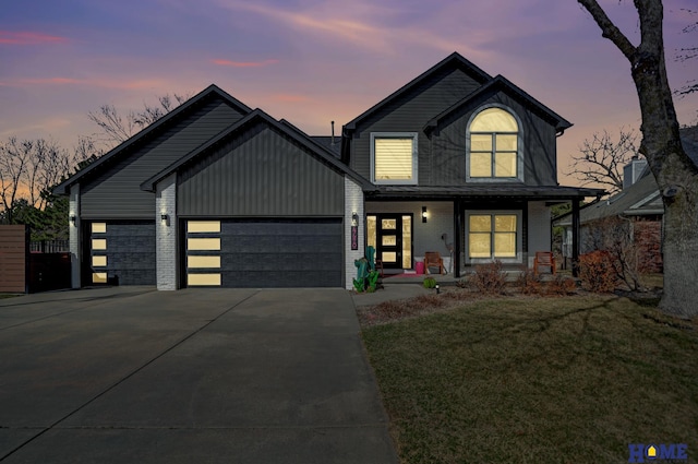 view of front facade with driveway, a porch, a garage, a lawn, and brick siding