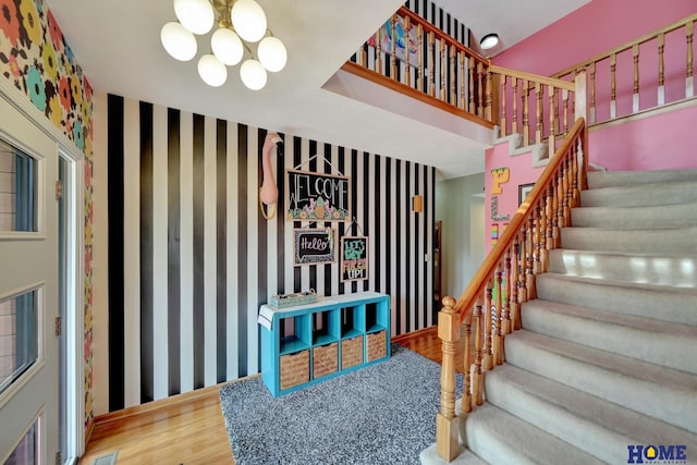 stairs featuring a chandelier and wood finished floors