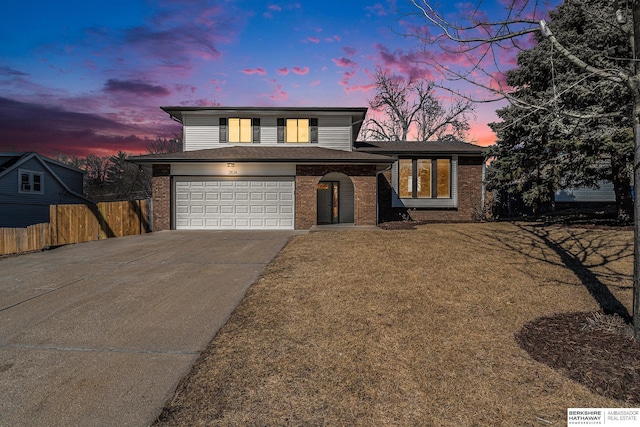 view of front of property featuring fence, a yard, concrete driveway, a garage, and brick siding