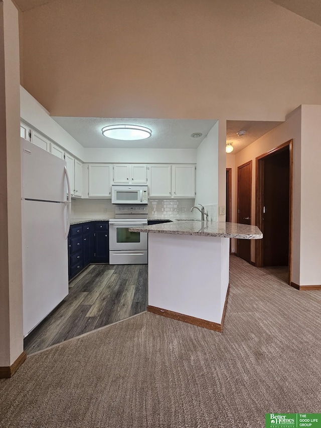 kitchen with backsplash, light stone countertops, a peninsula, white appliances, and dark colored carpet