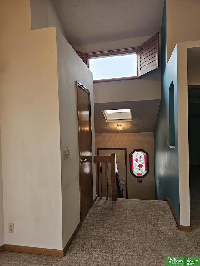 hall featuring an upstairs landing, carpet, and baseboards