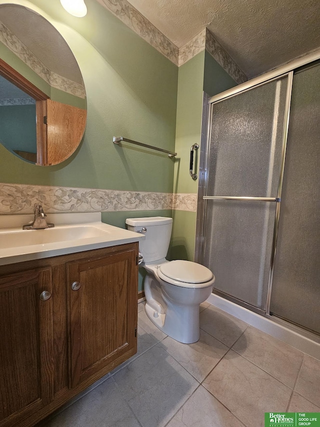 bathroom featuring vanity, wainscoting, a stall shower, and a textured ceiling