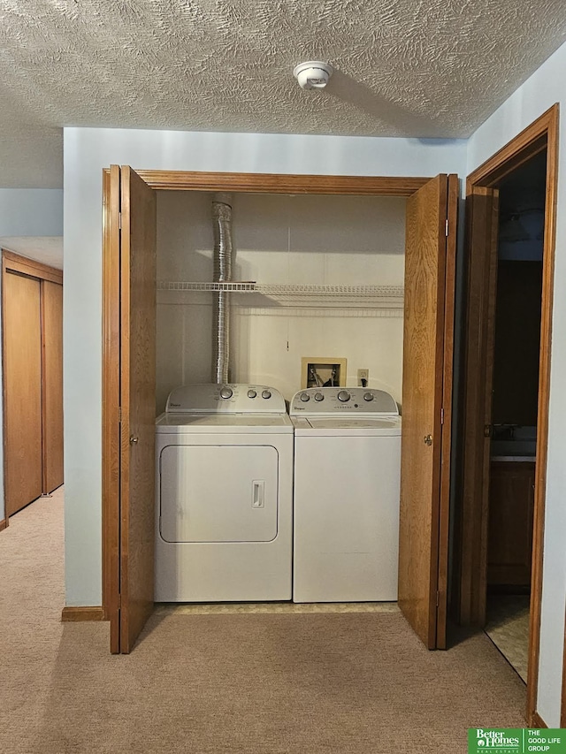 laundry room featuring laundry area, a textured ceiling, carpet, and separate washer and dryer