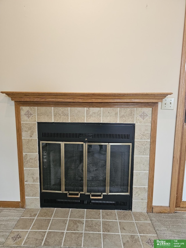 room details with baseboards and a tiled fireplace