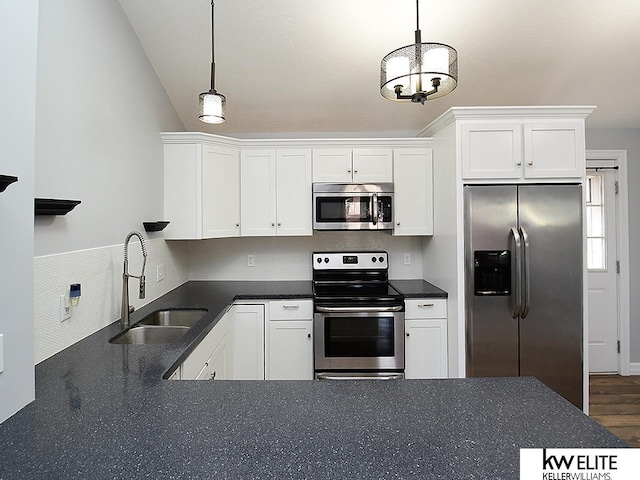 kitchen featuring white cabinets, pendant lighting, stainless steel appliances, and a sink