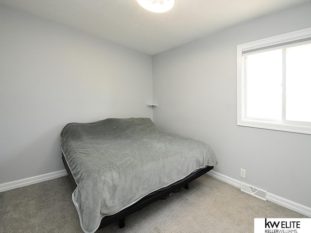 bedroom featuring visible vents, baseboards, and carpet