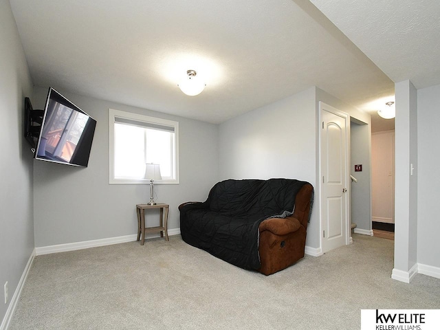 living area featuring carpet and baseboards